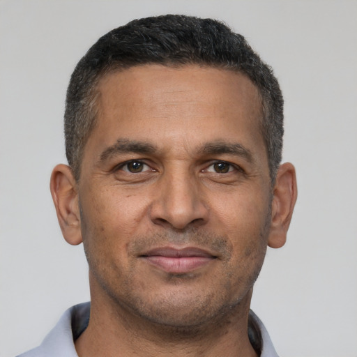 Joyful latino adult male with short  brown hair and brown eyes
