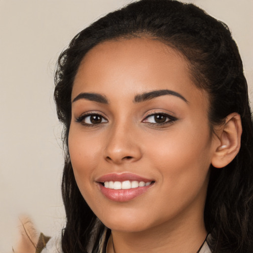 Joyful latino young-adult female with long  black hair and brown eyes