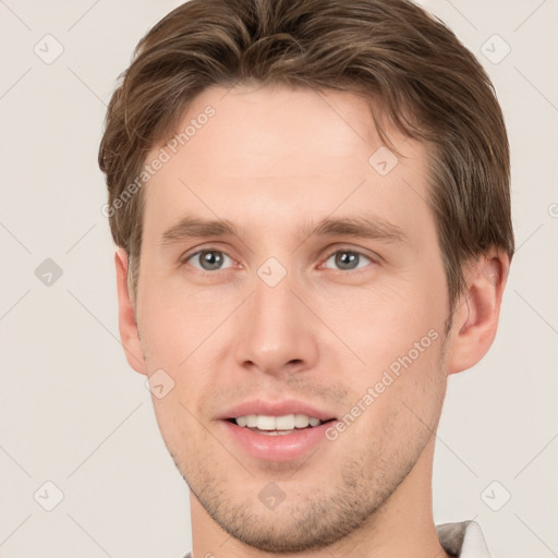 Joyful white young-adult male with short  brown hair and grey eyes