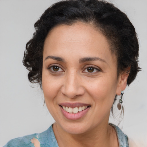 Joyful latino adult female with medium  brown hair and brown eyes