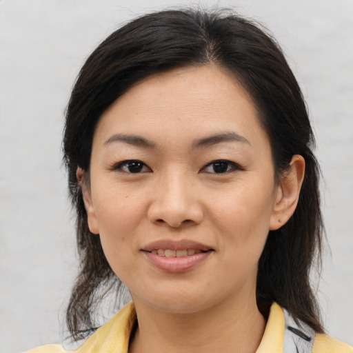Joyful asian young-adult female with medium  brown hair and brown eyes