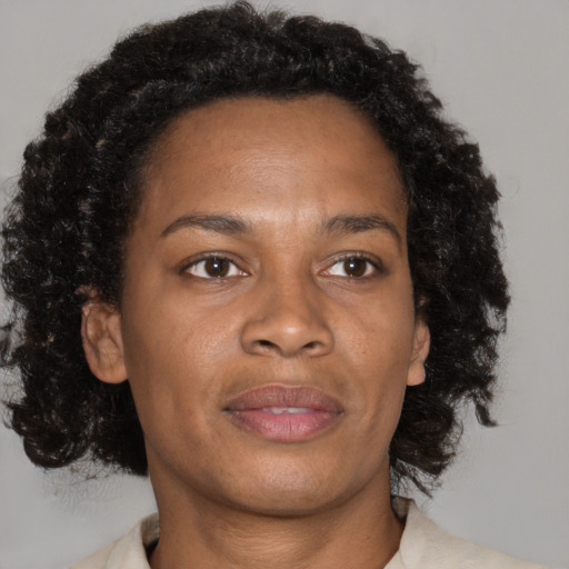 Joyful black adult female with medium  brown hair and brown eyes