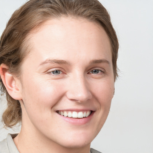 Joyful white young-adult female with medium  brown hair and blue eyes