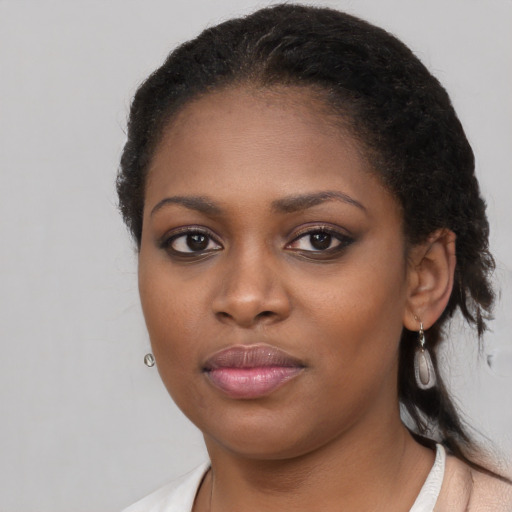 Joyful black young-adult female with long  black hair and brown eyes