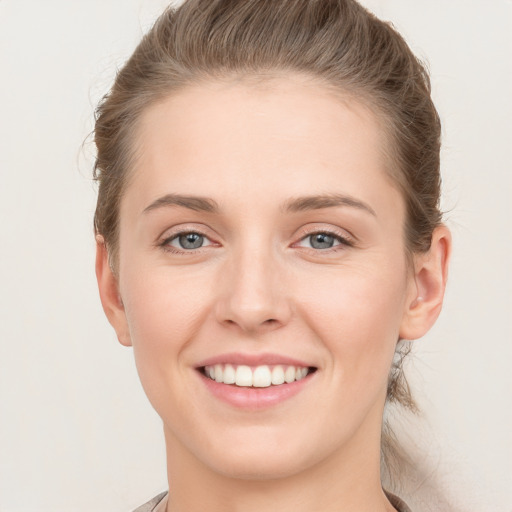 Joyful white young-adult female with short  brown hair and grey eyes