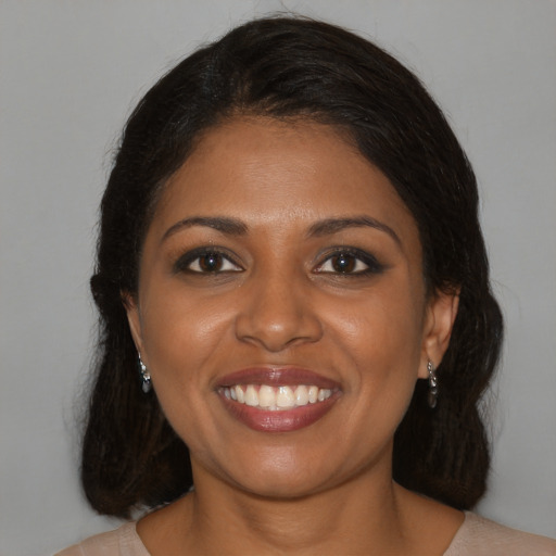 Joyful black young-adult female with medium  brown hair and brown eyes