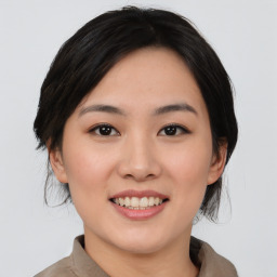 Joyful asian young-adult female with medium  black hair and brown eyes