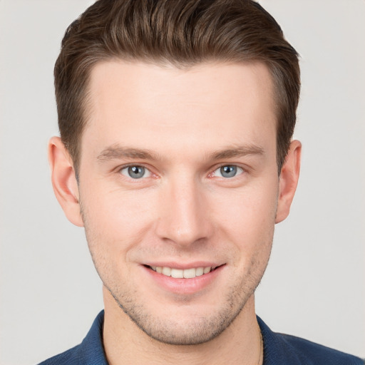 Joyful white young-adult male with short  brown hair and grey eyes