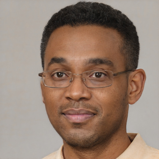 Joyful black adult male with short  black hair and brown eyes