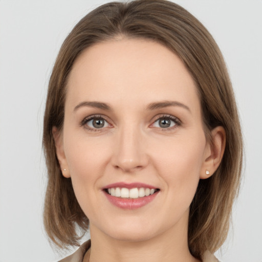 Joyful white young-adult female with medium  brown hair and grey eyes