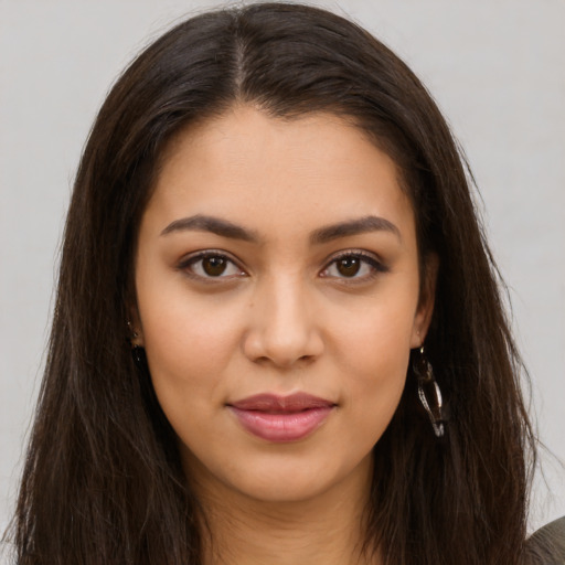 Joyful latino young-adult female with long  brown hair and brown eyes