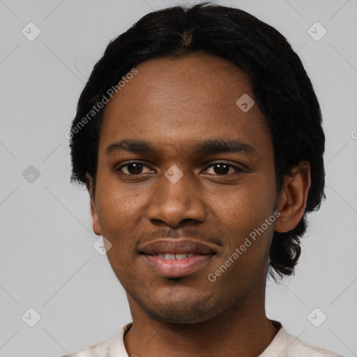 Joyful black young-adult male with short  black hair and brown eyes