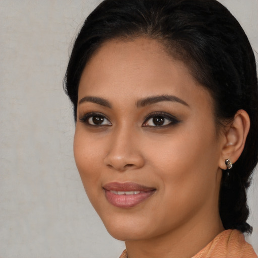 Joyful latino young-adult female with short  black hair and brown eyes