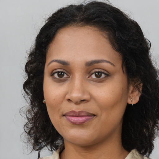 Joyful black young-adult female with long  brown hair and brown eyes