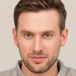 Joyful white young-adult male with short  brown hair and grey eyes