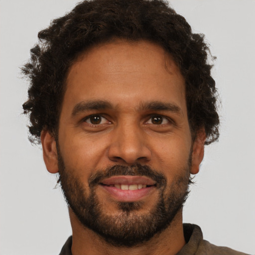 Joyful black young-adult male with short  brown hair and brown eyes