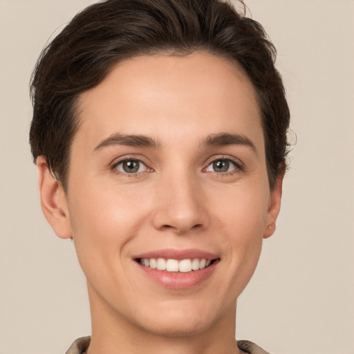 Joyful white young-adult female with short  brown hair and grey eyes