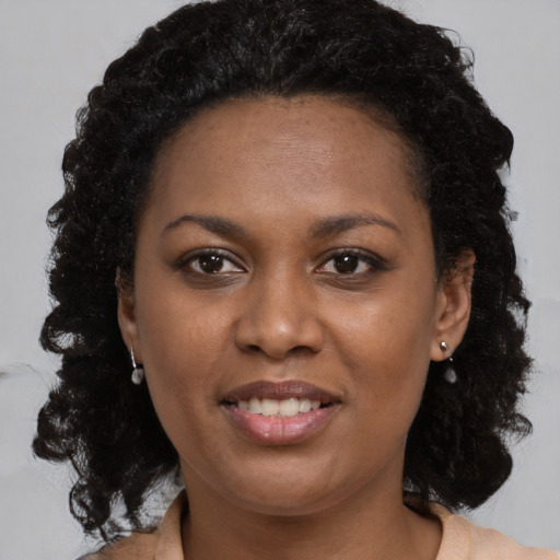 Joyful black young-adult female with medium  brown hair and brown eyes