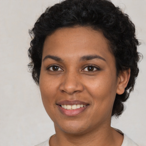 Joyful latino young-adult female with short  black hair and brown eyes