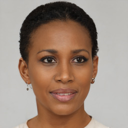 Joyful black young-adult female with short  black hair and brown eyes