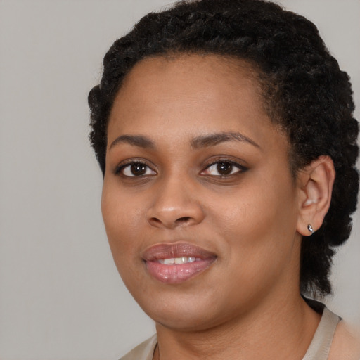 Joyful black young-adult female with short  black hair and brown eyes