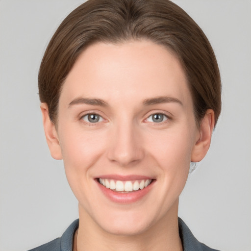 Joyful white young-adult female with short  brown hair and grey eyes