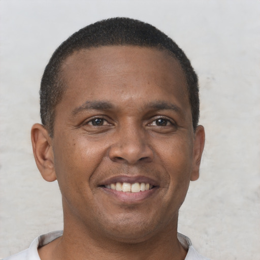 Joyful black young-adult male with short  brown hair and brown eyes