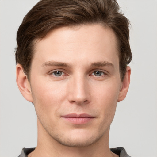 Joyful white young-adult male with short  brown hair and grey eyes