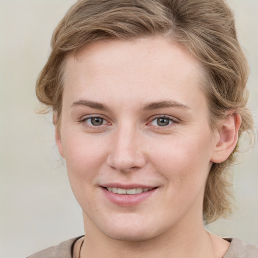 Joyful white young-adult female with medium  brown hair and blue eyes