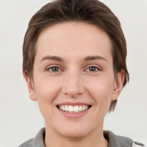 Joyful white young-adult female with short  brown hair and grey eyes