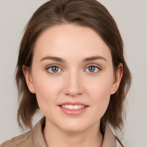 Joyful white young-adult female with medium  brown hair and grey eyes