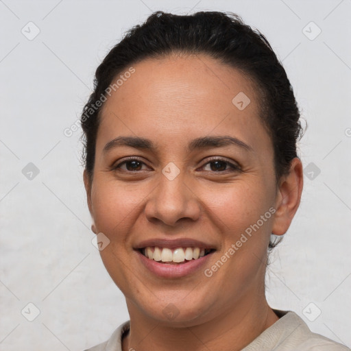 Joyful latino young-adult female with short  brown hair and brown eyes