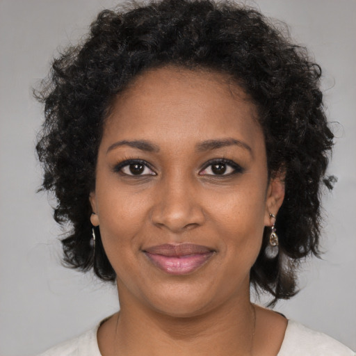 Joyful black young-adult female with medium  brown hair and brown eyes