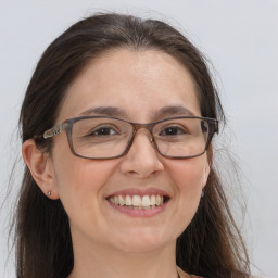 Joyful white adult female with long  brown hair and brown eyes