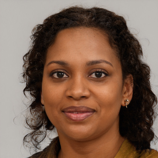 Joyful black young-adult female with long  brown hair and brown eyes