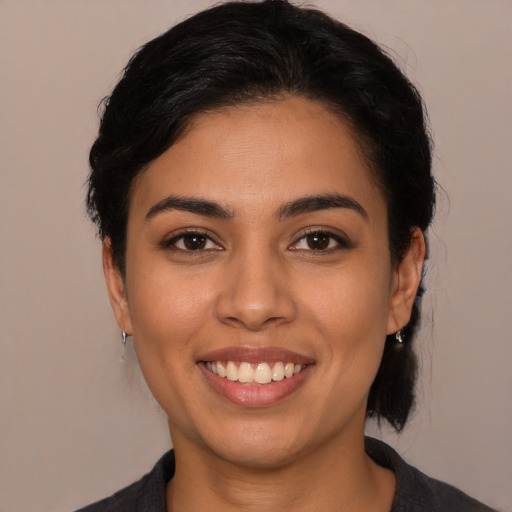 Joyful latino young-adult female with medium  black hair and brown eyes