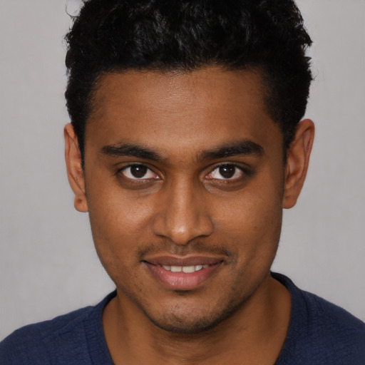 Joyful black young-adult male with short  brown hair and brown eyes
