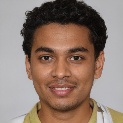 Joyful black young-adult male with short  brown hair and brown eyes