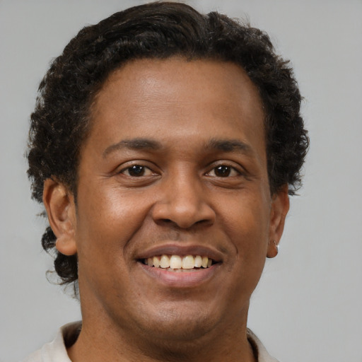 Joyful black adult male with short  brown hair and brown eyes
