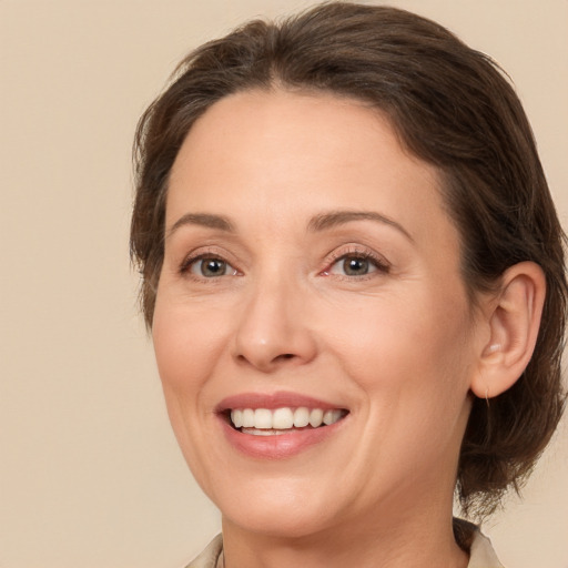 Joyful white adult female with medium  brown hair and brown eyes