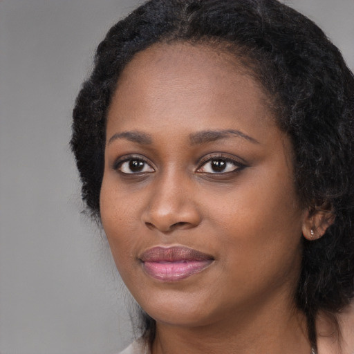 Joyful black young-adult female with long  black hair and brown eyes