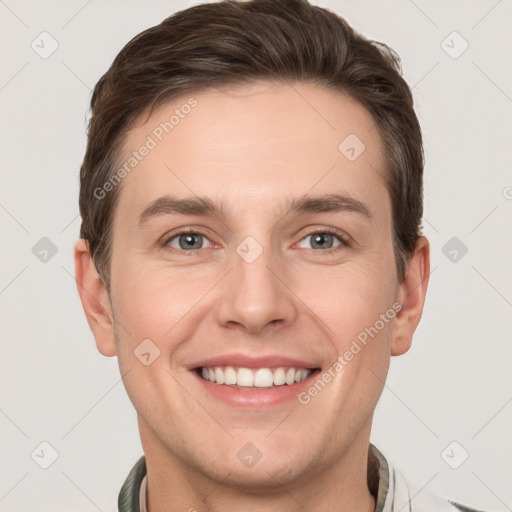 Joyful white young-adult male with short  brown hair and grey eyes