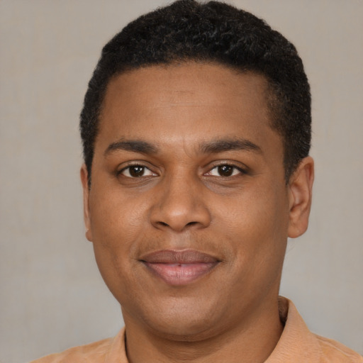 Joyful black young-adult male with short  brown hair and brown eyes