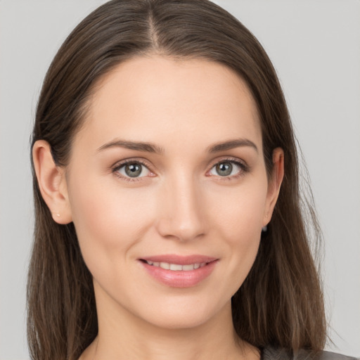 Joyful white young-adult female with long  brown hair and grey eyes