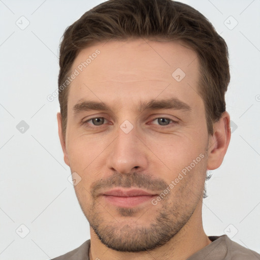 Joyful white young-adult male with short  brown hair and grey eyes