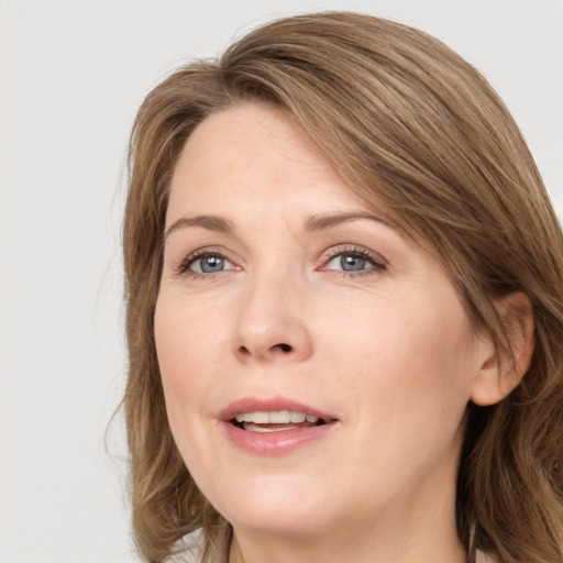 Joyful white adult female with medium  brown hair and grey eyes