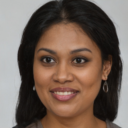 Joyful black young-adult female with medium  brown hair and brown eyes