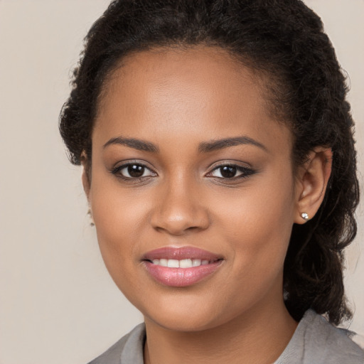 Joyful black young-adult female with medium  brown hair and brown eyes