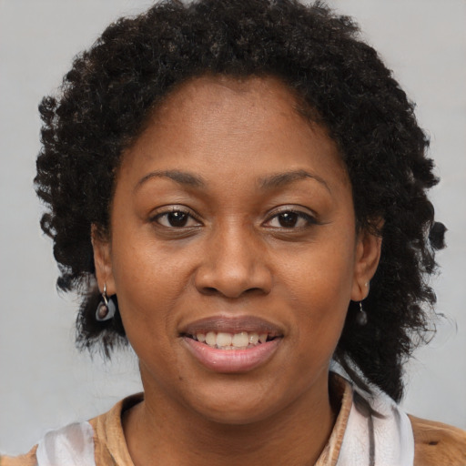 Joyful black adult female with short  brown hair and brown eyes