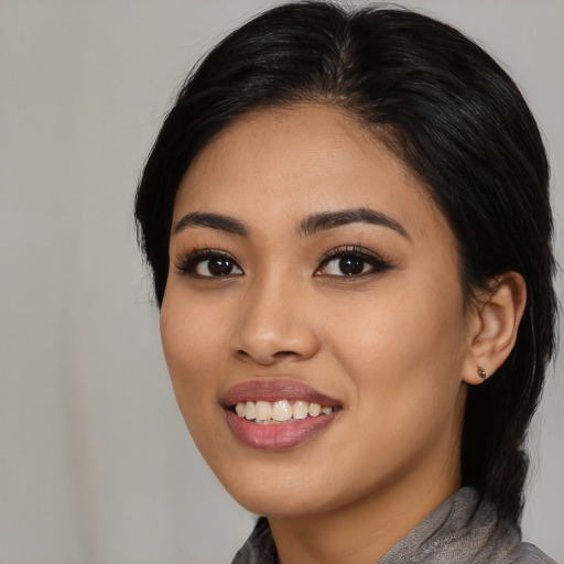 Joyful latino young-adult female with medium  black hair and brown eyes